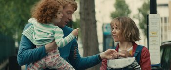 Movie still from “About Time” (2013), directed by Richard Curtis – A man holding a child and a woman holding a box; Medium shot, Over the shoulder angle