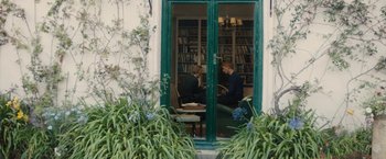 Movie still from “About Time” (2013), directed by Richard Curtis – Two men sitting at a table in front of a bookshelf; Wide shot, Over the shoulder angle