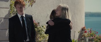 Movie still from “About Time” (2013), directed by Richard Curtis – Two women hugging each other in front of a building; Medium shot, Over the shoulder angle