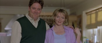 Movie still from “About a Boy” (2002), directed by Chris Weitz – A man and a woman standing next to each other; Medium shot, Low angle