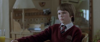 Movie still from “About a Boy” (2002), directed by Chris Weitz – A boy in a red sweater and a red tie; Close Up shot, Low angle