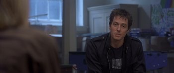 Movie still from “About a Boy” (2002), directed by Chris Weitz – A man sitting in front of a woman in front of a window; Close Up shot, Over the shoulder angle