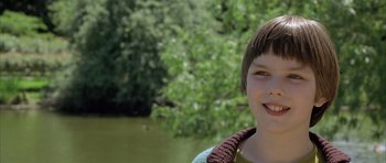 Movie still from “About a Boy” (2002), directed by Chris Weitz – A young boy standing next to a body of water; Close Up shot, Low angle