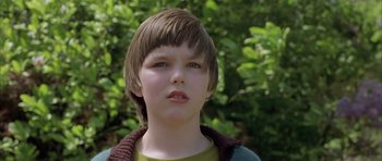 Movie still from “About a Boy” (2002), directed by Chris Weitz – A young boy with brown hair wearing a green shirt; Close Up shot, Low angle