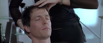 Movie still from “About a Boy” (2002), directed by Chris Weitz – A man getting his hair combed by a woman; Close Up shot, Over the shoulder angle