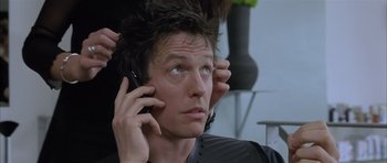 Movie still from “About a Boy” (2002), directed by Chris Weitz – A man is talking on a cell phone; Close Up shot, Over the shoulder angle