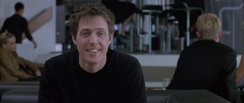 Movie still from “About a Boy” (2002), directed by Chris Weitz – A person sitting in a room; Close Up shot, Over the shoulder angle