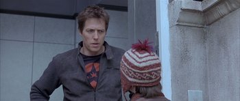 Movie still from “About a Boy” (2002), directed by Chris Weitz – A man and a woman standing next to each other; Close Up shot, Over the shoulder angle