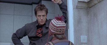 Movie still from “About a Boy” (2002), directed by Chris Weitz – A man standing in front of a mirror talking to another man; Medium shot, Over the shoulder angle