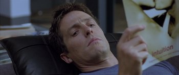 Movie still from “About a Boy” (2002), directed by Chris Weitz – A person laying on a chair reading a book; Close Up shot, Low angle