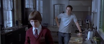 Movie still from “About a Boy” (2002), directed by Chris Weitz – A man and a boy standing in a room; Medium shot, Over the shoulder angle