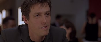 Movie still from “About a Boy” (2002), directed by Chris Weitz – A person wearing a suit; Close Up shot, Over the shoulder angle
