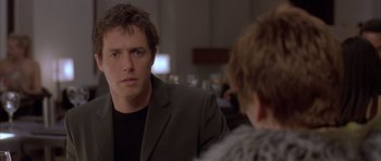 Movie still from “About a Boy” (2002), directed by Chris Weitz – A man sitting in front of another man in front of a table; Close Up shot, Over the shoulder angle