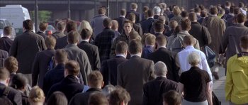 Movie still from “About a Boy” (2002), directed by Chris Weitz – A large group of people in business suits; Wide shot, Over the shoulder angle