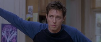 Movie still from “About a Boy” (2002), directed by Chris Weitz – A person wearing a black and blue shirt; Close Up shot, Over the shoulder angle