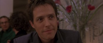 Movie still from “About a Boy” (2002), directed by Chris Weitz – A man's face with a flower in the background; Close Up shot, Over the shoulder angle