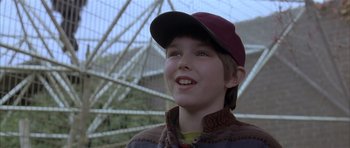 Movie still from “About a Boy” (2002), directed by Chris Weitz – A young boy wearing a baseball cap and a sweater; Close Up shot, Low angle