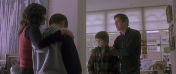 Movie still from “About a Boy” (2002), directed by Chris Weitz – Two men and a boy standing in front of a window; Medium shot, Over the shoulder angle