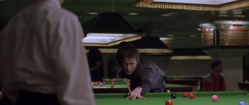 Movie still from “About a Boy” (2002), directed by Chris Weitz – A man is playing pool in a billiards room; Medium shot, Over the shoulder angle
