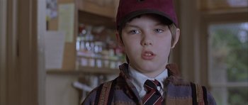 Movie still from “About a Boy” (2002), directed by Chris Weitz – A young boy wearing a hat and a tie; Close Up shot, Over the shoulder angle