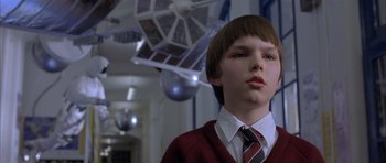 Movie still from “About a Boy” (2002), directed by Chris Weitz – A boy in a red sweater and a tie; Close Up shot, Low angle