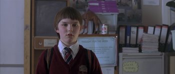 Movie still from “About a Boy” (2002), directed by Chris Weitz – A boy in a red sweater and a tie; Close Up shot, Low angle
