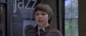 Movie still from “About a Boy” (2002), directed by Chris Weitz – A young boy wearing a sweater and a tie; Close Up shot, Low angle
