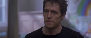 Movie still from “About a Boy” (2002), directed by Chris Weitz – A person wearing a black t - shirt; Close Up shot, Over the shoulder angle