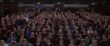 Movie still from “About a Boy” (2002), directed by Chris Weitz – A large group of people wearing maroon shirts; Wide shot, High angle