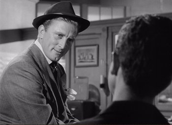Movie still from “Ace in the Hole” (1951), directed by Billy Wilder – A man wearing a hat is talking to another man; Close Up shot, Over the shoulder angle