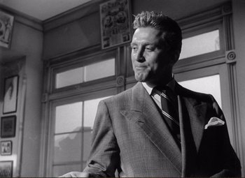 Movie still from “Ace in the Hole” (1951), directed by Billy Wilder – Black and white photograph of a man wearing a suit and tie; Close Up shot, Low angle