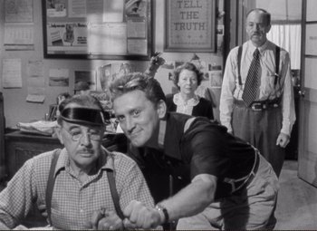 Movie still from “Ace in the Hole” (1951), directed by Billy Wilder – An old photo of two men and two women; Medium shot, Over the shoulder angle