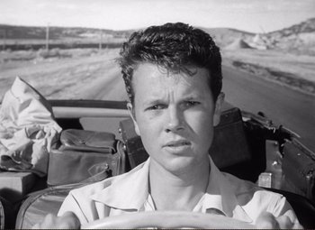 Movie still from “Ace in the Hole” (1951), directed by Billy Wilder – A man driving a car on the side of the road; Close Up shot, Low angle