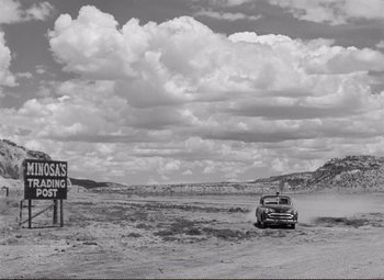 Movie still from “Ace in the Hole” (1951), directed by Billy Wilder – An old car parked in the middle of a desert; Extreme Wide shot, Low angle