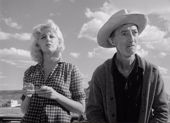 Movie still from “Ace in the Hole” (1951), directed by Billy Wilder – An older man and a young woman standing next to each other; Medium shot, Low angle