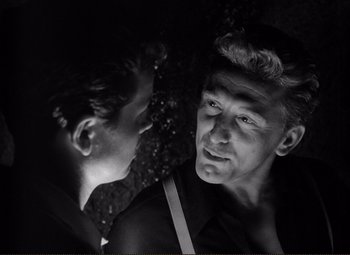 Movie still from “Ace in the Hole” (1951), directed by Billy Wilder – A man is looking at another man in a black and white photo; Close Up shot, Low angle