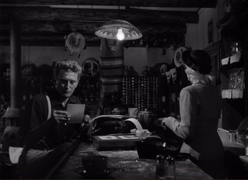 Movie still from “Ace in the Hole” (1951), directed by Billy Wilder – A man and a woman sitting at a table in a restaurant; Medium shot, Low angle