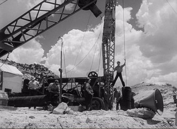 Movie still from “Ace in the Hole” (1951), directed by Billy Wilder – A black - and - white photo of men working on a construction site; Extreme Wide shot, Low angle