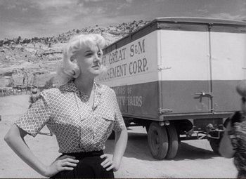 Movie still from “Ace in the Hole” (1951), directed by Billy Wilder – A woman standing in front of a truck; Medium shot, Low angle