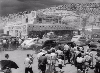 Movie still from “Ace in the Hole” (1951), directed by Billy Wilder – A black and white photo of a crowd of people in front of an old building; Extreme Wide shot, High angle