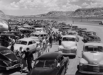 Movie still from “Ace in the Hole” (1951), directed by Billy Wilder – A black and white photo of a crowd of cars on a road; Extreme Wide shot, High angle