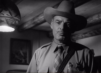 Movie still from “Ace in the Hole” (1951), directed by Billy Wilder – A black and white photo of a man in a sheriff's uniform; Medium shot, Low angle