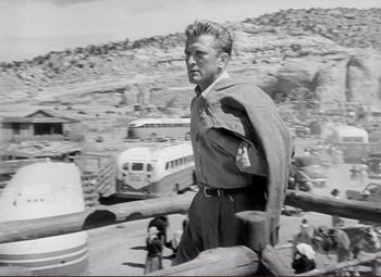 Movie still from “Ace in the Hole” (1951), directed by Billy Wilder – An old black and white photo of a man standing on top of a hill; Medium shot, Low angle