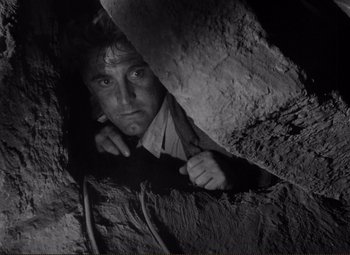 Movie still from “Ace in the Hole” (1951), directed by Billy Wilder – A black - and - white photo of a man in a cave; Close Up shot, Low angle