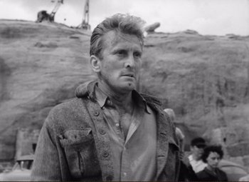 Movie still from “Ace in the Hole” (1951), directed by Billy Wilder – Black and white photograph of a man in front of a rock wall; Close Up shot, Low angle