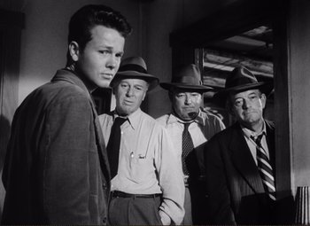 Movie still from “Ace in the Hole” (1951), directed by Billy Wilder – A black and white photo of a group of men in hats; Medium shot, Low angle
