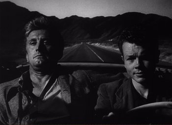 Movie still from “Ace in the Hole” (1951), directed by Billy Wilder – A black and white photo of two men in the back of a car; Medium shot, Low angle