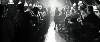 Movie still from “Adam Resurrected” (2008), directed by Paul Schrader – A group of people sitting at tables in a room; Wide shot, Over the shoulder angle