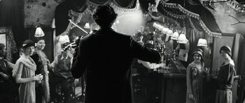 Movie still from “Adam Resurrected” (2008), directed by Paul Schrader – A man in a suit is holding a violin; Medium shot, Over the shoulder angle