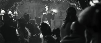 Movie still from “Adam Resurrected” (2008), directed by Paul Schrader – A woman is playing the violin in front of an audience; Medium shot, Low angle
